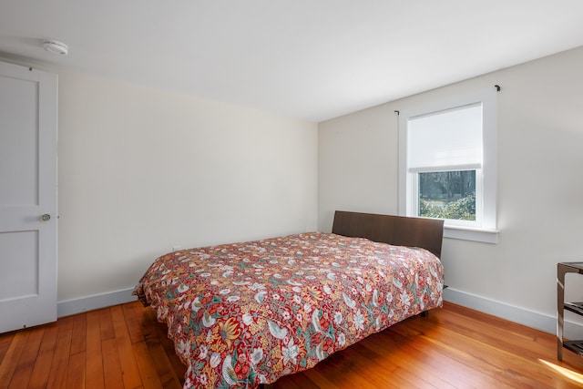 bedroom with hardwood / wood-style floors and baseboards