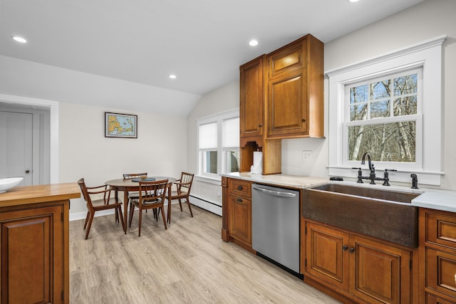 kitchen featuring brown cabinets, a baseboard radiator, stainless steel dishwasher, vaulted ceiling, and a sink