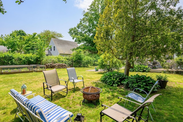 view of yard featuring a garden, an outdoor fire pit, and fence