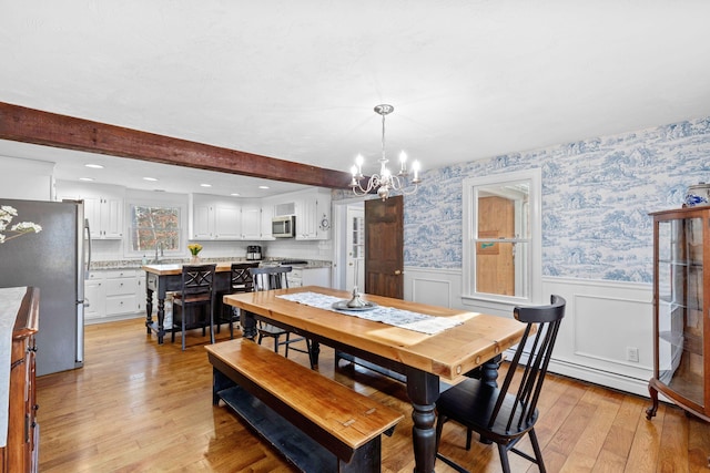 dining area with a wainscoted wall, light wood finished floors, a baseboard radiator, beamed ceiling, and wallpapered walls