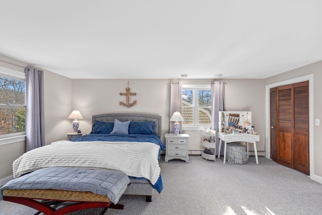 bedroom with carpet floors, a baseboard radiator, a closet, and baseboards