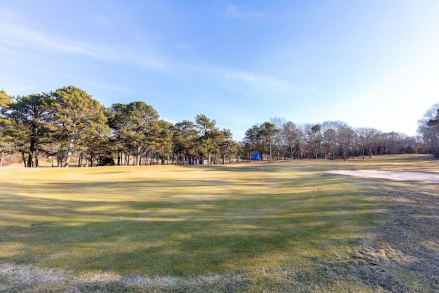 surrounding community featuring golf course view and a lawn