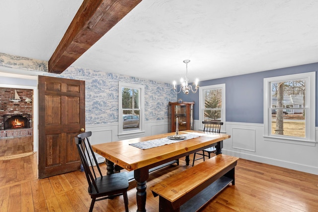 dining area featuring a wealth of natural light, a wainscoted wall, and light wood finished floors