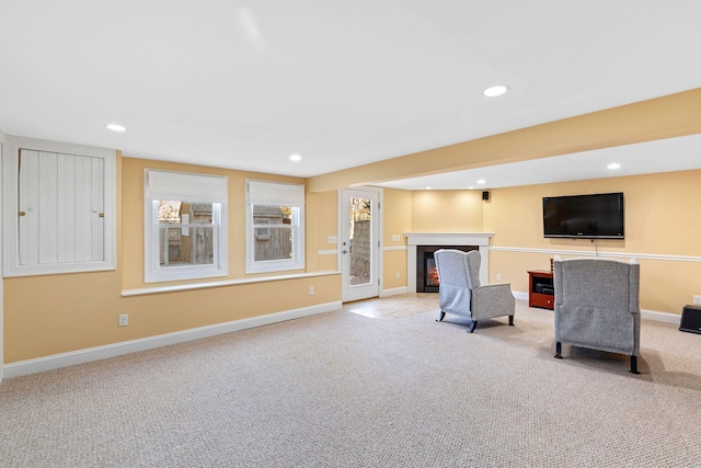 interior space featuring a lit fireplace, baseboards, carpet flooring, and recessed lighting