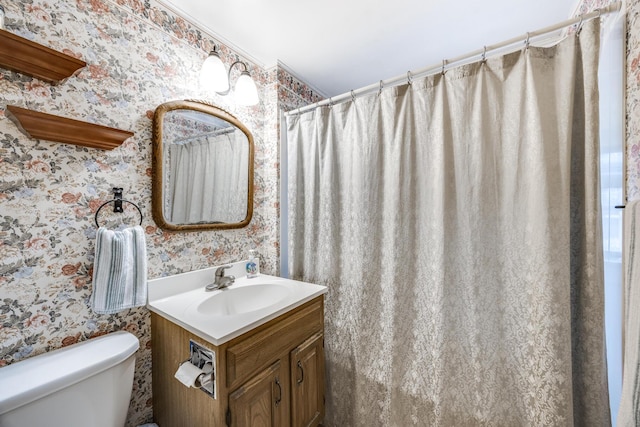 bathroom with ornamental molding, toilet, and vanity