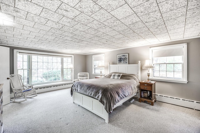 bedroom with carpet flooring and a baseboard heating unit