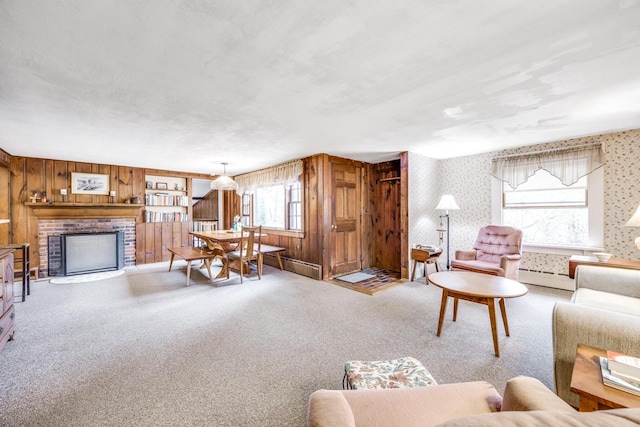 living room featuring a fireplace, carpet flooring, wooden walls, and a baseboard heating unit