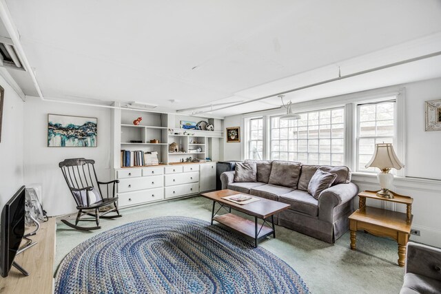 living room with built in shelves and light colored carpet