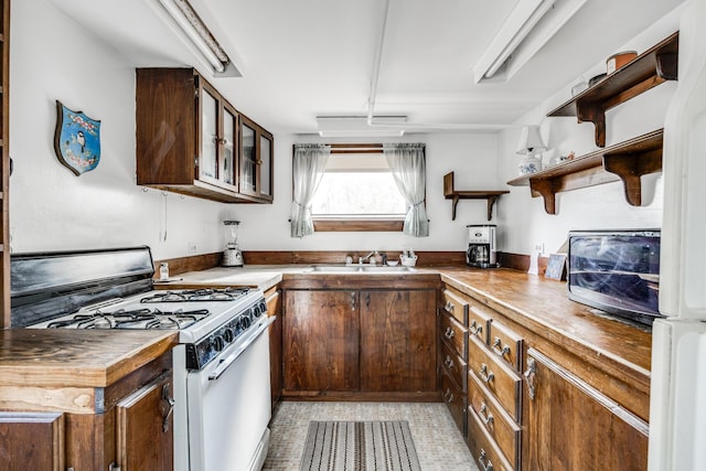 kitchen featuring white range with gas stovetop, sink, and wood counters