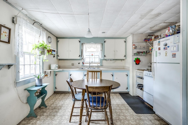 kitchen with sink, white appliances, and white cabinets