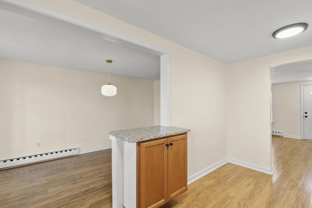kitchen with brown cabinets, baseboards, a baseboard heating unit, and light wood finished floors
