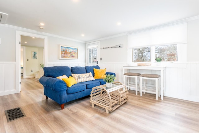 living room with crown molding and light hardwood / wood-style floors