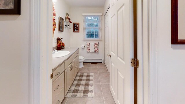 bathroom with vanity, toilet, tile patterned floors, and baseboard heating