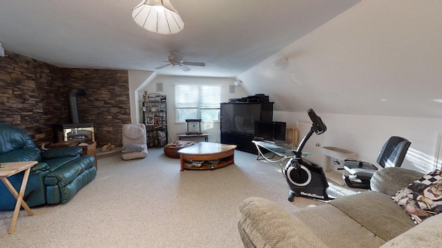 living room featuring a wood stove, ceiling fan, and lofted ceiling