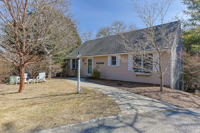 view of front of house with a front lawn and a shingled roof