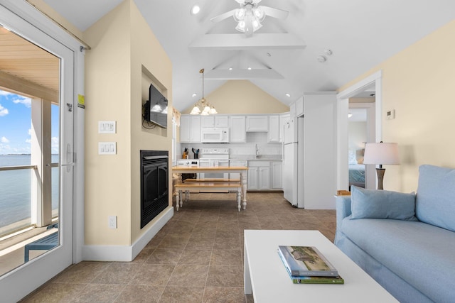 496 Shore Rd Unit 16, Truro, MA 02666 - living area featuring a glass covered fireplace, a ceiling fan, recessed lighting, lofted ceiling, and a water view