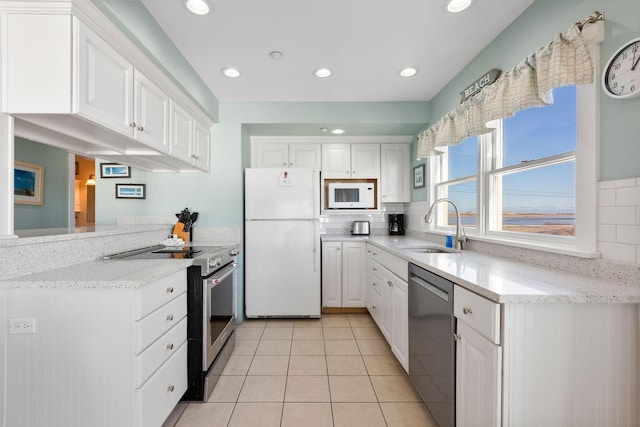 kitchen featuring white cabinetry, sink, light tile patterned flooring, and appliances with stainless steel finishes