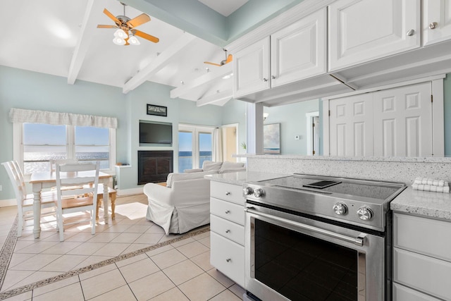 kitchen featuring white cabinetry, a healthy amount of sunlight, light tile patterned floors, and electric stove