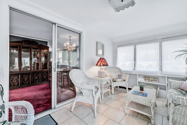 sunroom / solarium featuring a notable chandelier