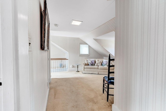 interior space with vaulted ceiling and light carpet