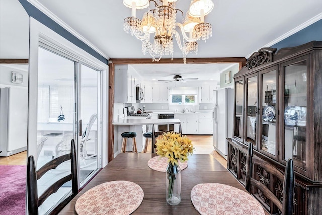 dining room with ceiling fan with notable chandelier, light hardwood / wood-style floors, sink, and beamed ceiling