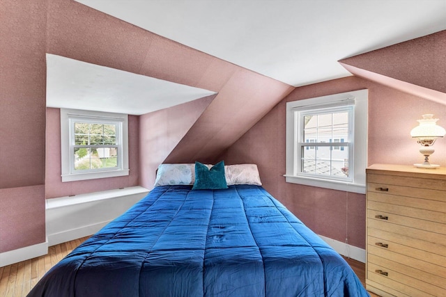 bedroom with vaulted ceiling and hardwood / wood-style floors