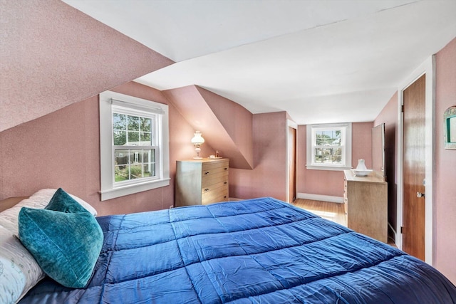 bedroom featuring hardwood / wood-style flooring and lofted ceiling