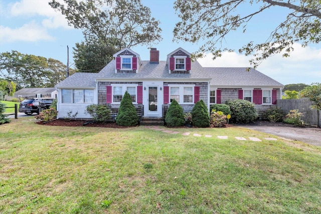 cape cod-style house featuring a front yard