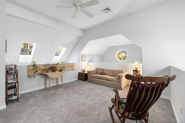 carpeted living room with vaulted ceiling with skylight and ceiling fan