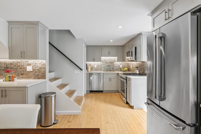 27 Court St Unit U7B, Provincetown, MA 02657 - kitchen with high quality appliances, tasteful backsplash, gray cabinets, light wood finished floors, and recessed lighting