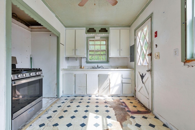 91 Baxter Rd, Hyannis, MA 02601 - kitchen with stainless steel gas range, light flooring, light countertops, white cabinetry, and ceiling fan