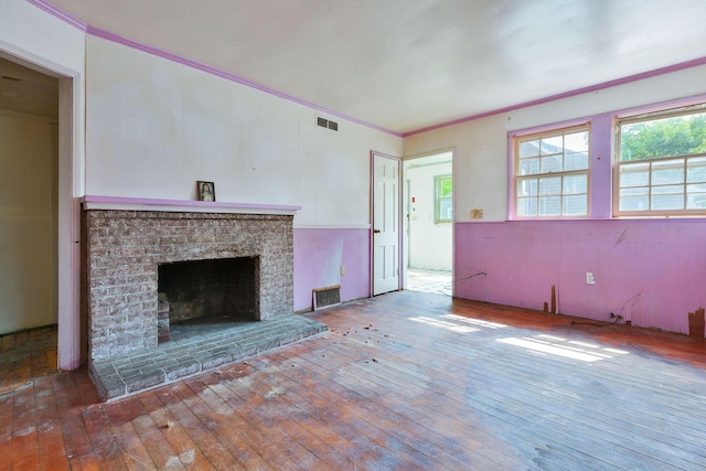 91 Baxter Rd, Hyannis, MA 02601 - unfurnished living room with wood-type flooring, crown molding, and a brick fireplace