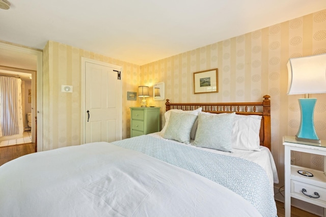 bedroom featuring wallpapered walls and wood finished floors