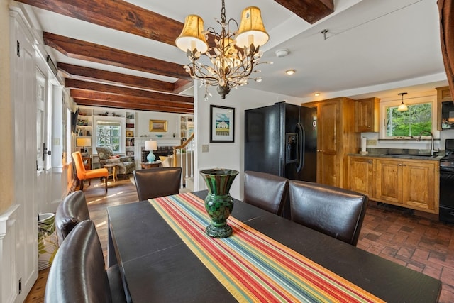 dining room with a chandelier, beamed ceiling, stairs, and brick patterned flooring
