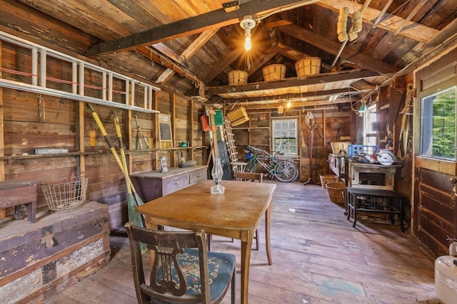dining space with wood walls, vaulted ceiling, wood-type flooring, and wood ceiling