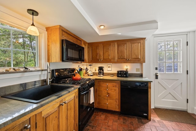 kitchen featuring black appliances, brick floors, brown cabinets, and a sink