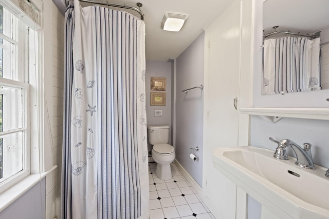 bathroom featuring a sink, toilet, tile patterned flooring, baseboards, and a shower with curtain