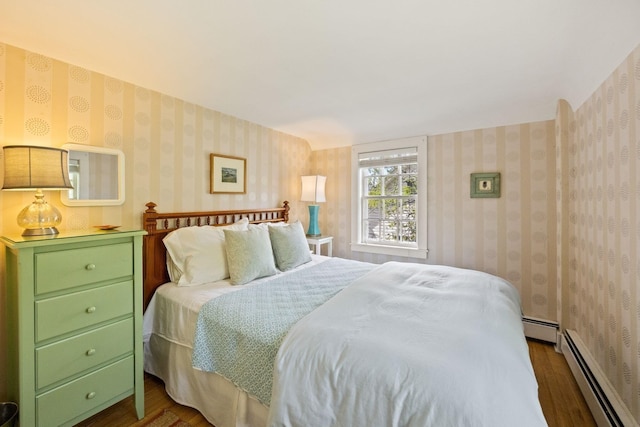 bedroom with baseboard heating, dark wood-style floors, and wallpapered walls