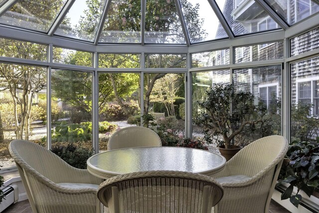 sunroom with a baseboard radiator and a healthy amount of sunlight