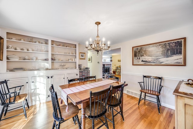 38 Rainbow Way, Harwich, MA 02645 - dining room featuring light wood-style floors, plenty of natural light, visible vents, and an inviting chandelier