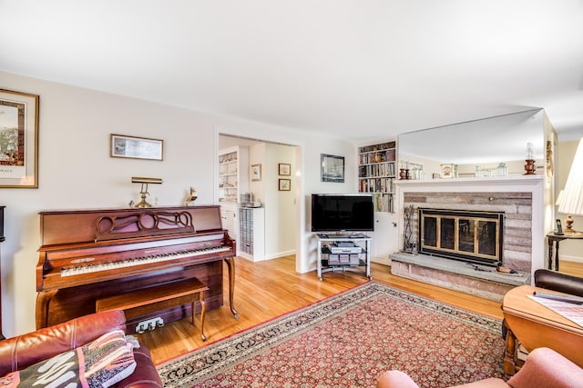 38 Rainbow Way, Harwich, MA 02645 - living room with built in shelves, wood finished floors, and a premium fireplace