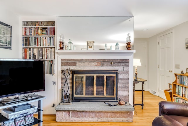 38 Rainbow Way, Harwich, MA 02645 - living area featuring a glass covered fireplace and wood finished floors