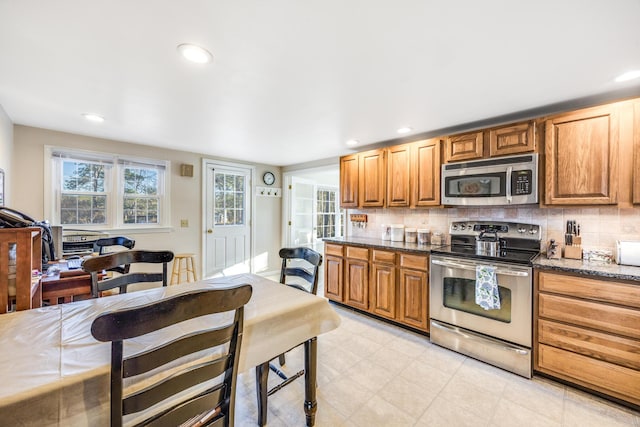 38 Rainbow Way, Harwich, MA 02645 - kitchen with dark stone counters, backsplash, brown cabinets, and stainless steel appliances