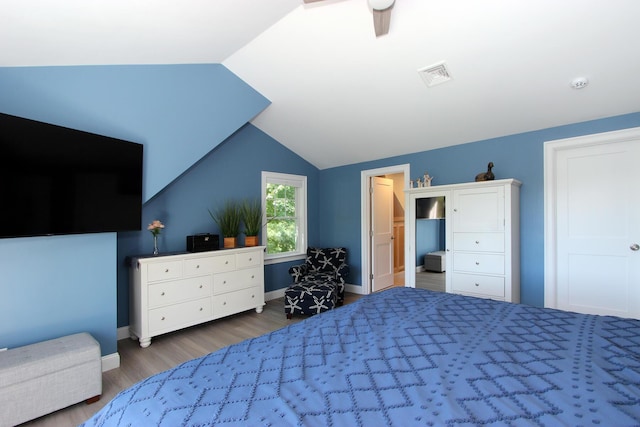 bedroom with ceiling fan, vaulted ceiling, and dark hardwood / wood-style floors