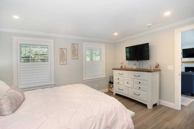 bedroom with light wood-type flooring and crown molding