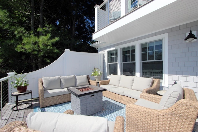 view of patio with an outdoor living space with a fire pit