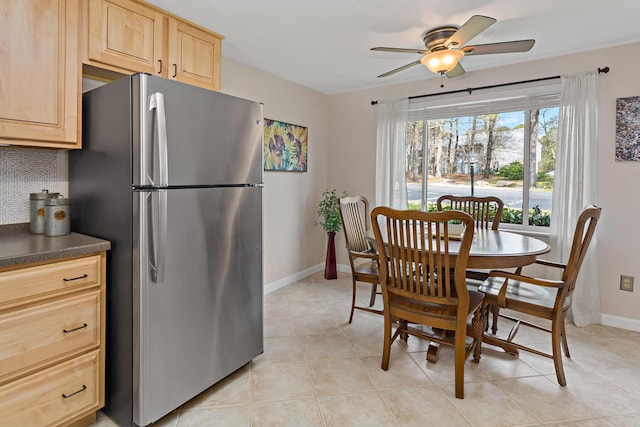 dining area with baseboards, ceiling fan, and light tile patterned floors