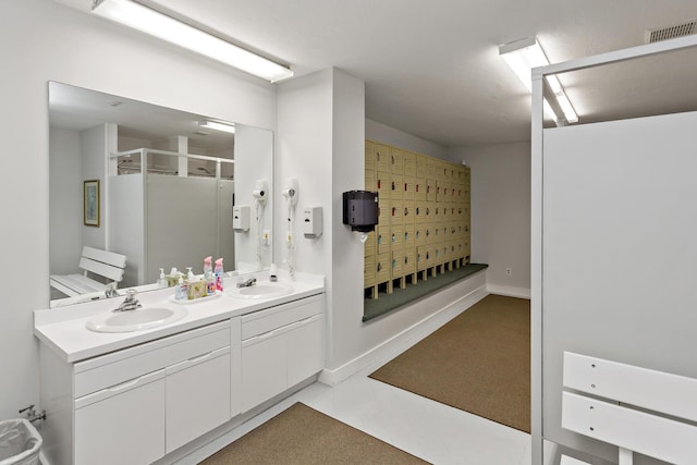 bathroom with visible vents, a sink, a stall shower, and double vanity
