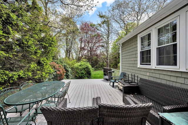 deck with outdoor dining space and view of scattered trees