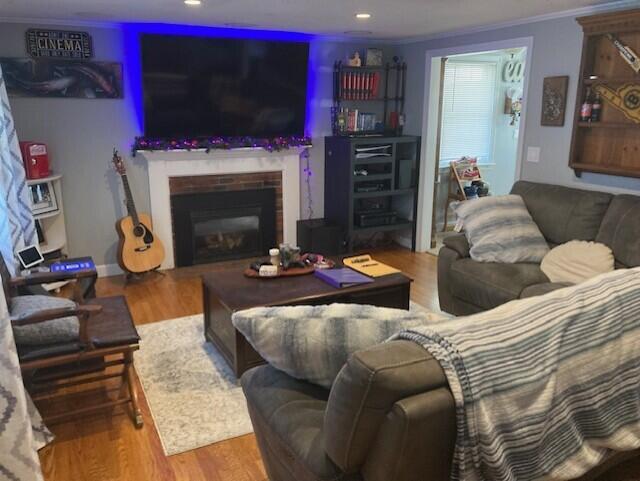 25 Buckwood Dr, South Yarmouth, MA 02664 - living room featuring wood finished floors, ornamental molding, recessed lighting, and a glass covered fireplace